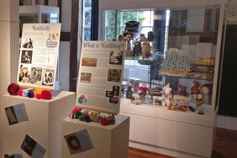 A display of colourful pom poms and knitting materials, part of the 2019 Knitwits exhibition