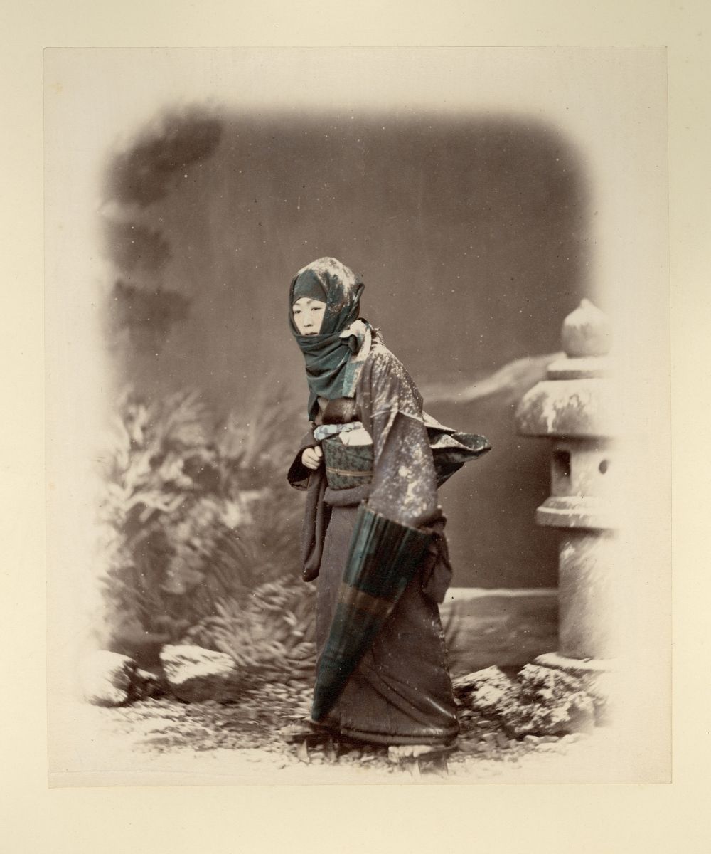 Hand-tinted photograph of a Japanese women walking in the snow