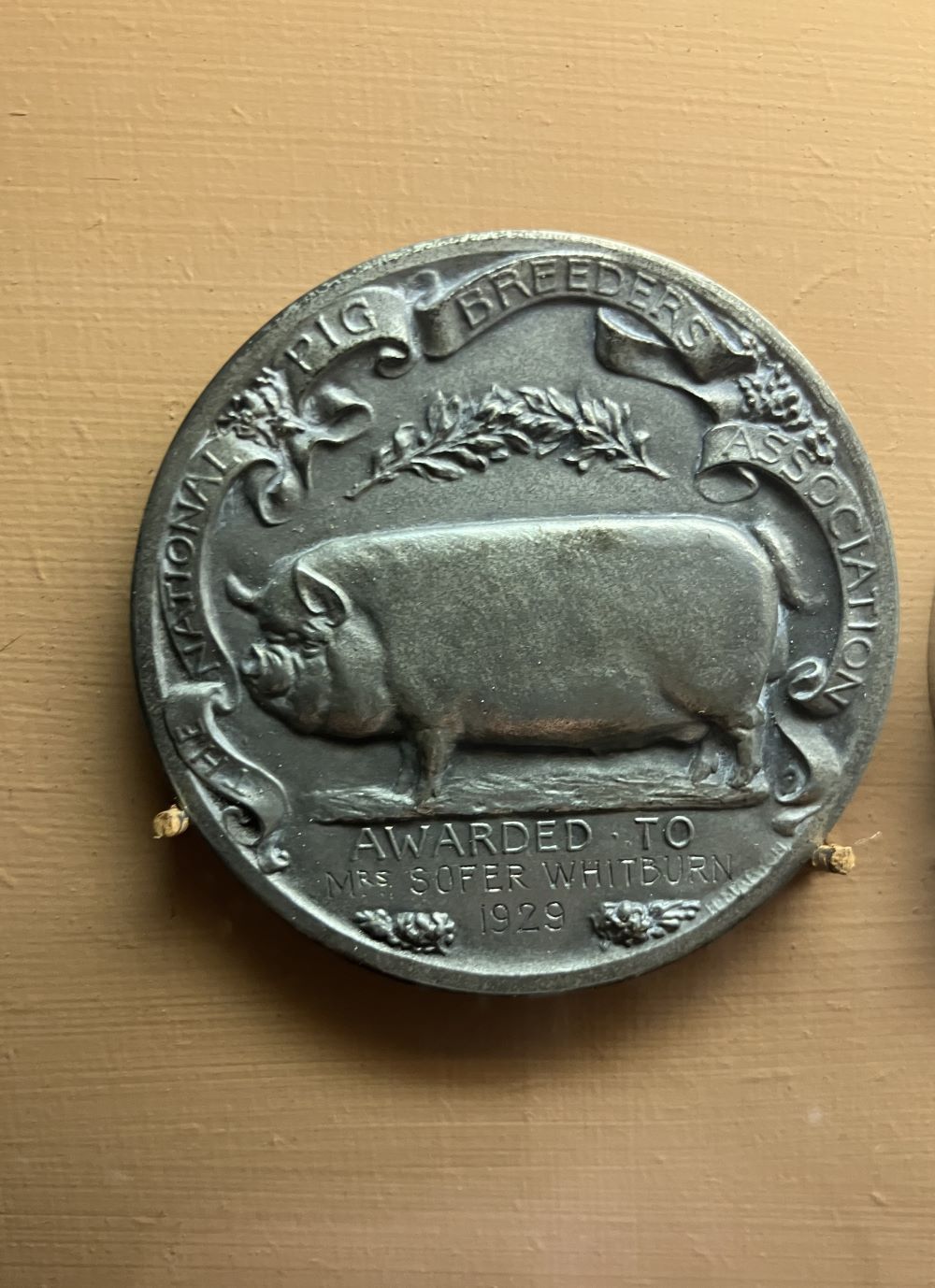 Silver medal with engraving of a pig. Inscription reads 'The National Pig Breeders Association. Awarded to Mrs Sofer Whitburn 1929.'