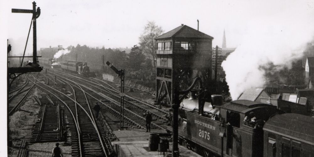 A black and white photo of a Southern Railway train leaving Horsham station