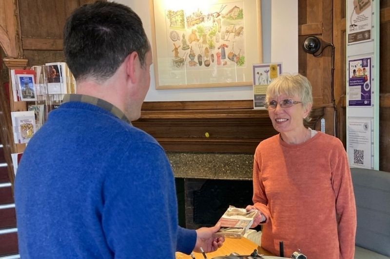 Two volunteers standing by the museum reception