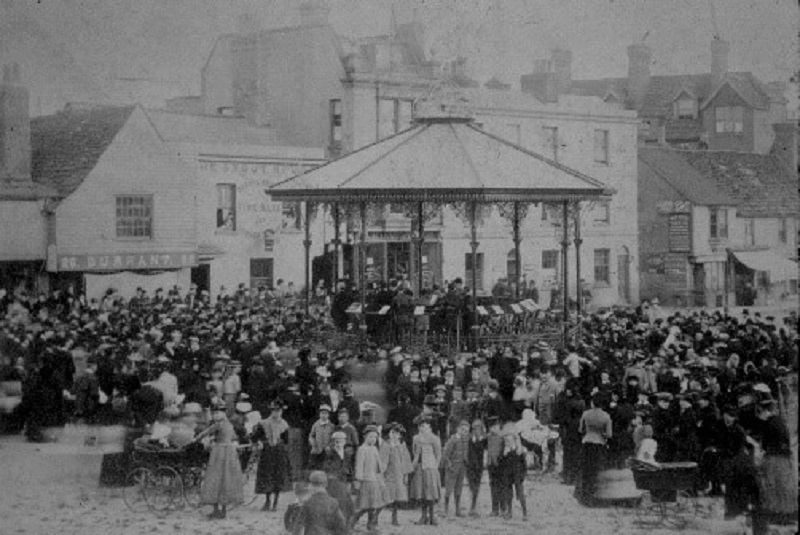 A black and white photo of a crowd gathered at Horsham bandstand
