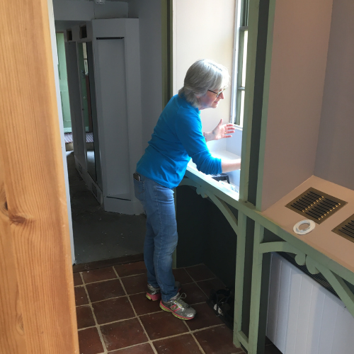 Jenny at Horsham Museum painting a window